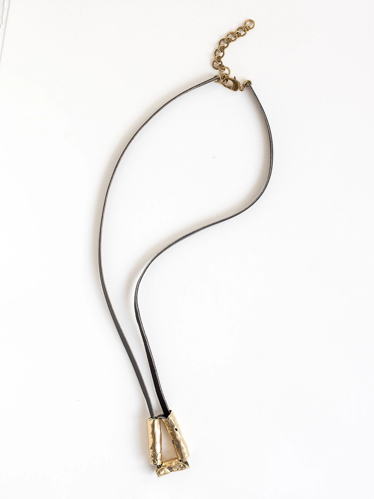 Long black leather necklace with a brass sculptural pendant by Michelle Ross