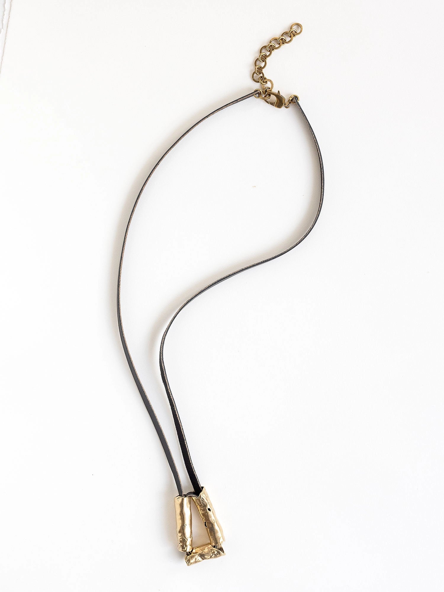 Long black leather necklace with a brass sculptural pendant by Michelle Ross