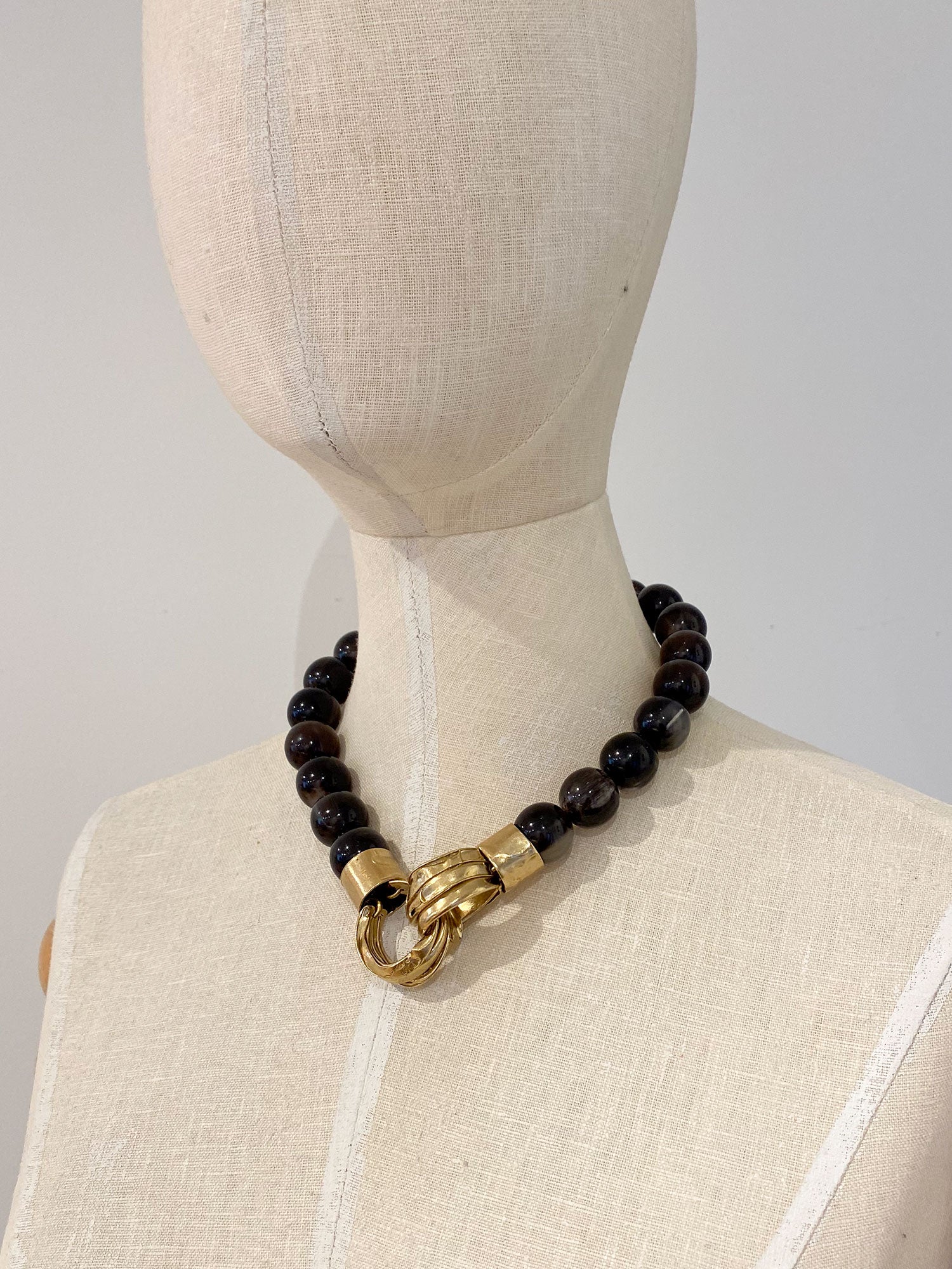 Necklace with horn beads and brass pendant